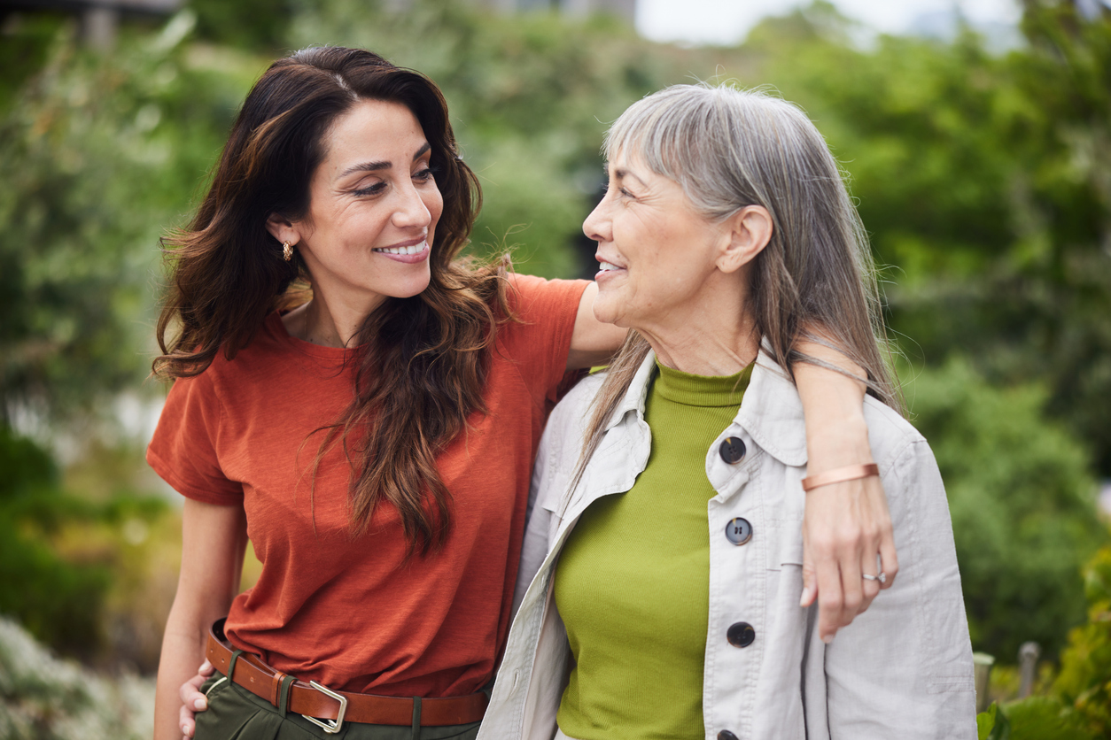 Two women sharing a warm embrace in a garden